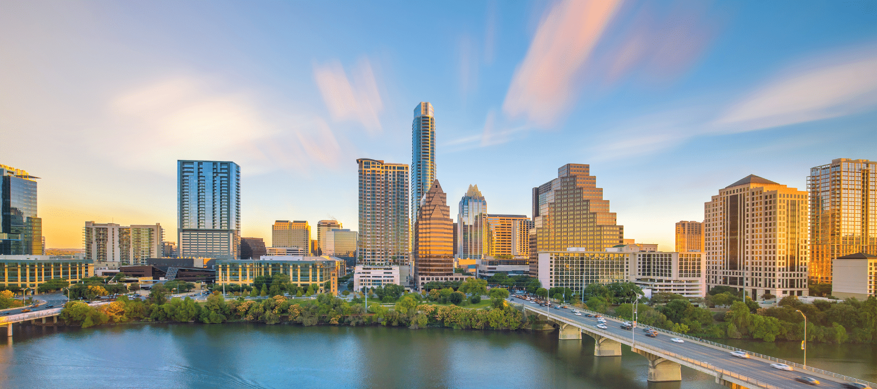 Austin, TX, skyline showcasing city buildings, a lake, and a highway